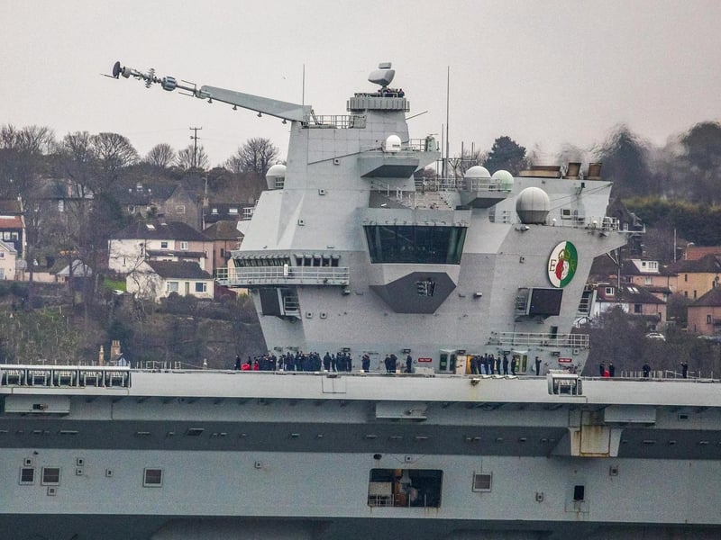 HMS Queen Elizabeth makes her way under the Forth Bridges as she prepares to dock at Rosyth dockyard for repairs, March 21 2024.