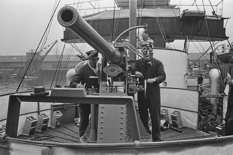 Naval officers inspecting the gun turret of a paddle steamer which has been repurposed as a minesweeper during World War II, circa 1940. (Photo by Fox Photos/Hulton Archive/Getty Images)