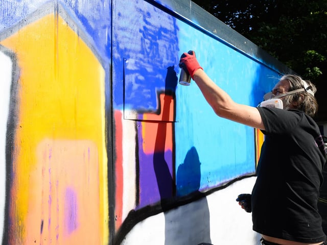 Pictured is: Toby Rabone adds more colour to his work. One of many artists at wok in Wiltshire Street and Meridian Road
Picture: Keith Woodland (140921-74)