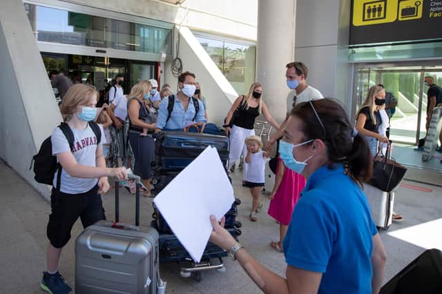 Tourists walk with their luggage outside the airport upon their arrival to Palma de Mallorca on July 27, 2020. Photo by JAIME REINA/AFP via Getty Images.