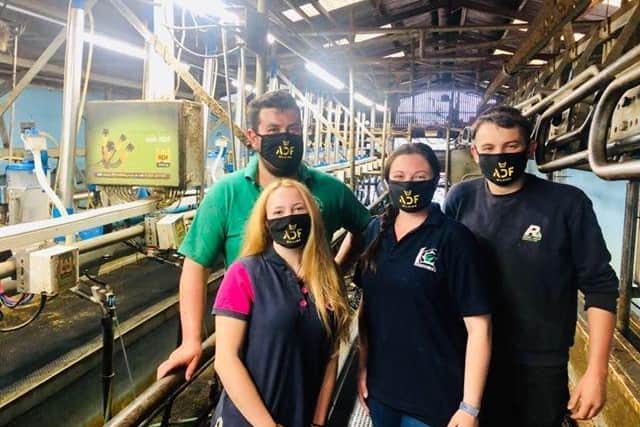 Dairy farmers pose in ADF Milking's masks