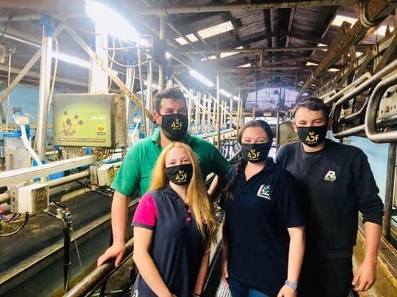 Dairy farmers pose in ADF Milking's masks