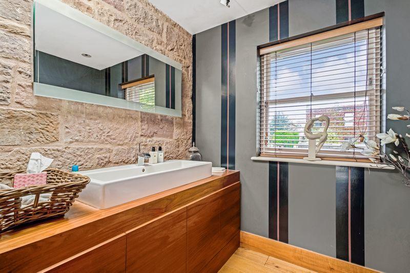 Spacious ground floor WC accessed off the lounge/dining area with contemporary styling and exposed stonework.