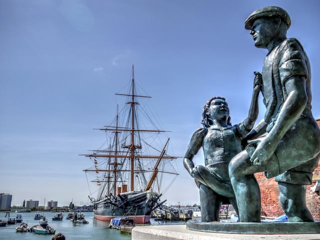 The mudlarks statue can be found as you enter the Historic Dockyard. It's easy to miss this bronze statue which commemorates the generations of Portsea children who enjoyed 'mudlarking' - entertaining travellers by retrieving coins they threw into the mud below the bridge to Portsmouth Harbour Station and Gosport Ferry. Boys and girls would scramble to find money tossed down, sometimes diving into the mud, performing handstands or dipping their heads in it. Many Portsea families lived in poverty, so the small change was welcomed.

The building of the new bus terminal in 1976-77 put an end to all that mucky fun!

In the background the pride of Queen Victoria's navy, HMS Warrior 1860.