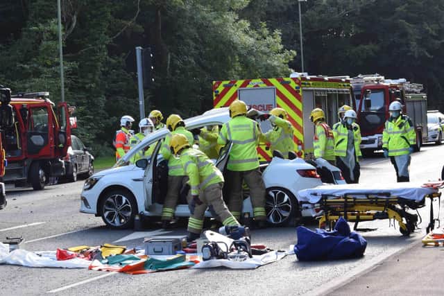 Firefighters battle to free the injured motorist from the car following a crash in Purbrook. Photo: Stuart Vaizey