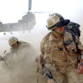 Sand and dust gets thrown up as No 3 Company the First Battalion The Grenadier Guards deploy out of an RAF Chinook Helicopter. Picture: Sergeant Will Craig/Crown Copyright