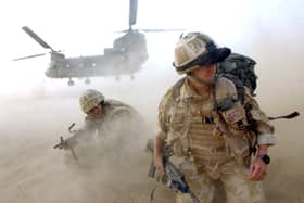 Sand and dust gets thrown up as No 3 Company the First Battalion The Grenadier Guards deploy out of an RAF Chinook Helicopter. Picture: Sergeant Will Craig/Crown Copyright