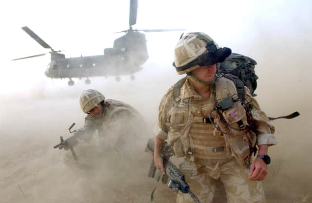 Sand and dust gets thrown up as No 3 Company the First Battalion The Grenadier Guards deploy out of an RAF Chinook Helicopter. Picture: Sergeant Will Craig/Crown Copyright