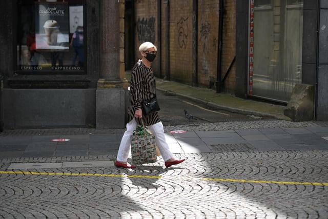 A shopper wears a face mask in the city centre of Sheffield (Photo by OLI SCARFF/AFP via Getty Images)