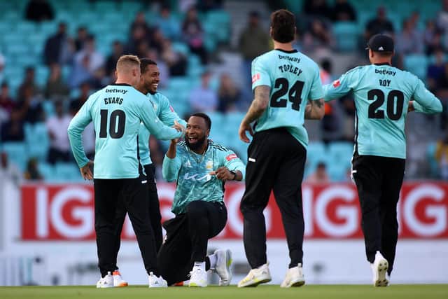 Kieron Pollard of Surrey celebrates with team mates after taking the wicket of Nick Gubbins . Photo by Ben Hoskins/Getty Images for Surrey CCC.