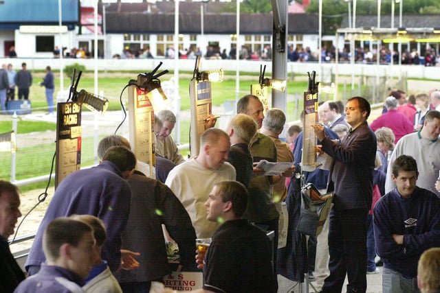 Laying the odds - Bookmakers in action as the crowds build up for the next race at Portsmouth Greyhound Stadium back in 2001. Picture: Mike Scaddan. 012884_0116