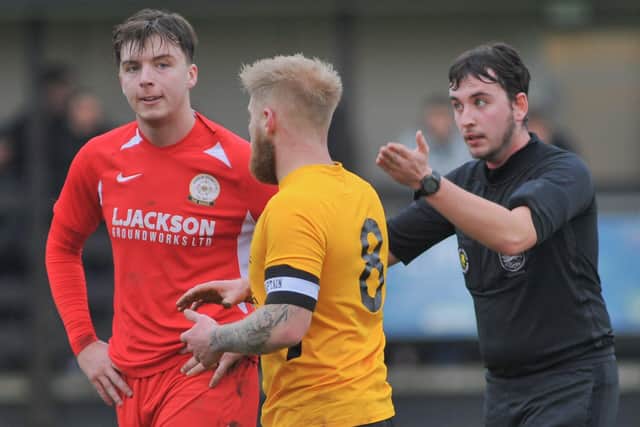 Horndean skipper Sam Hookey, left, and his Bashley counterpart Brad Morris are spoken to by referee Calum McFarlane. Picture: Martyn White