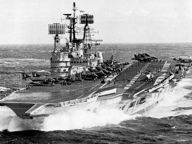 Seen in 1977 is HMS Ark Royal with a flight of Phantom, Buccaneer and Gannet aircraft on her flight deck.