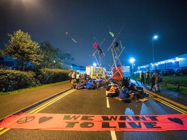 A handout picture released by Extinction Rebellion on September 5, 2020, shows Extinction Rebellion activists blocking the entrance to the News Corporation newpaper printers at Broxbourne, north of London on September 4, 2020, "to expose the failure of these corporations to accurately report on the climate and ecological emergency". Climate change protesters in Britain blockaded two newspaper printing sites early Saturday, disrupting the distribution of titles including The Times, the Daily Telegraph and The Sun. Credit: TOM OLDHAM/Extinction Rebellion/AFP via Getty Images.
