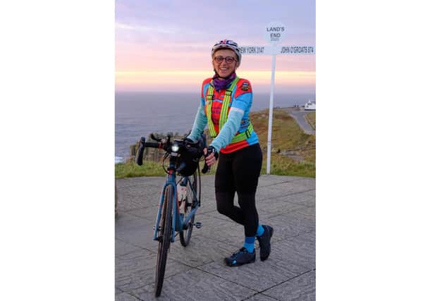 Marcia Roberts has become the first woman to complete the cycle from Land's End to John o'Groats and back again. Pictured: Marcia at the finish line at Land's End