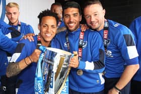 Danny Rose, centre, and Noel Hunt, right, celebrate Pompey's League Two title triumph with Kyle Bennett. Picture: Joe Pepler
