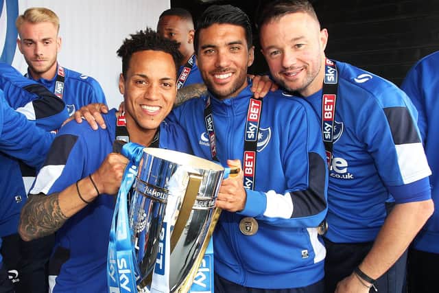 Danny Rose, centre, and Noel Hunt, right, celebrate Pompey's League Two title triumph with Kyle Bennett. Picture: Joe Pepler