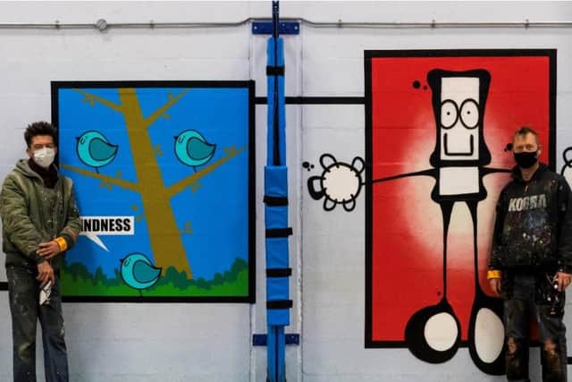 Pictured left to right, Portsmouth artists Fark and My Dog Sighs pictured with part of the new mural celebrating Portsmouth's social care workers.