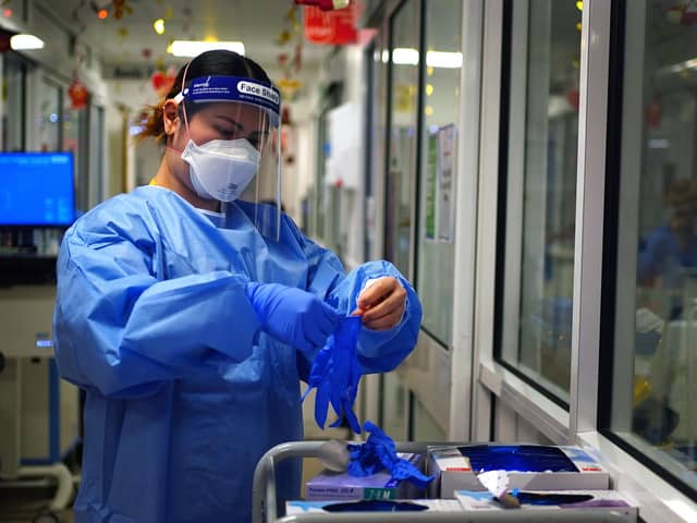 A nurse puts on PPE in a ward for Covid patients at King's College Hospital, in south east London.