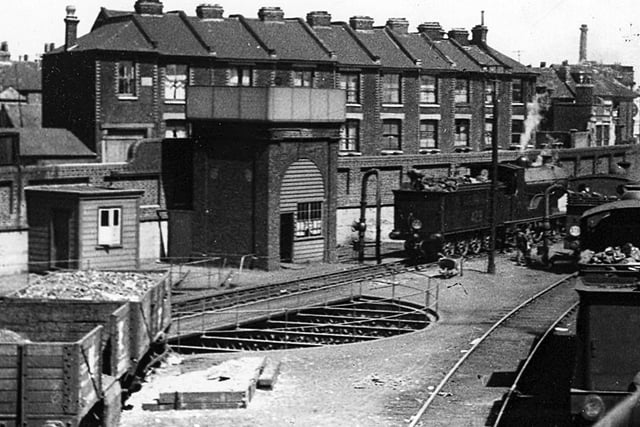 Water tower and turntable at Portsmouth and Southsea Railway

Another feature of the railway line into Portsmouth now long gone was the engine turntable. In Portsmouth there were at one time three of these. One outside the Harbour station on the up side, this one outside the low level Town station and the other in the roundhouse at Fratton depot.
This view was taken from Jacob's ladder footbridge and to the rear can be seen  houses in Canal Walk. Later the new signal box was built on the site and even this is now redundant as the new signalling centre at Havant as since been commissioned.