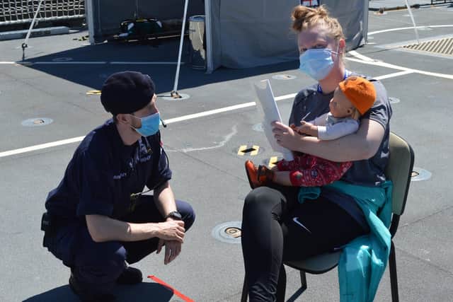 Surgeon Lieutenant Alexander Bishop, the ship's medial officer, checks on civilians in a humanitarian mission exercise. Photo: Royal Navy