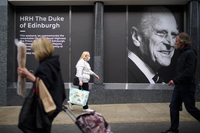 Shoppers walk past a photograph commemorating Prince Philip, Duke Of Edinburgh. Picture: Christopher Furlong/Getty Images