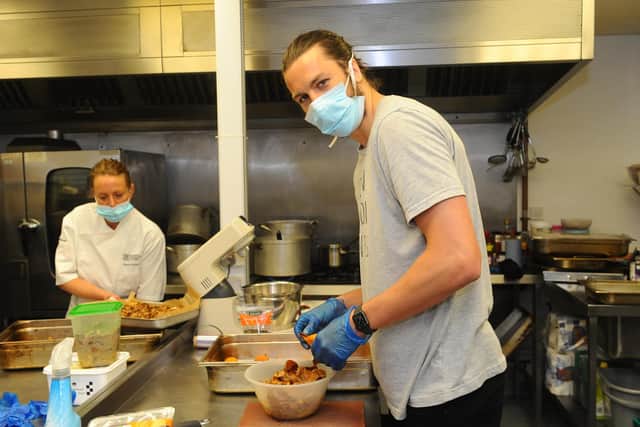 A team of staff and volunteers from the cafe at Landport Interactive in Portsmouth, on behalf of Enable Ability are cooking and providing hot meals to anyone in the local area who is isolated or in need of food at this time. Portsmouth FC players Christian Burgess and Sean Raggett have also been volunteering their time. Pictured is: Portsmouth FC player Christian Burgess in the kitchen.
Picture: Sarah Standing (300420-8118)