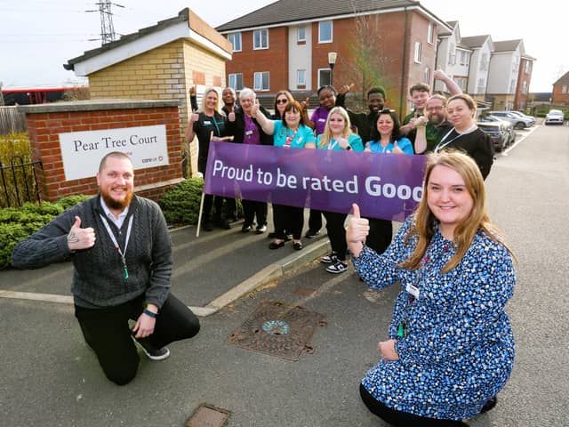 Home Manager Aimee Sparks with Deputy Manager Adrian Ballinger (crouching) celebrating the award with the team at Pear Tree Court.