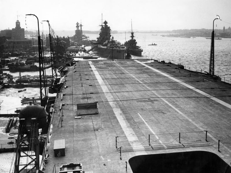 The Royal Navy Nelson-class battleship HMS Rodney and the Revenge-class battleship HMS Royal Oak can bee seen tied up at anchor as viewed from the flat top flight deck of the fleet aircraft carrier HMS Ark Royal in Portsmouth Dockyard on 23 November 1938 in Portsmouth, United Kingdom.  (Photo by Reg Speller/Fox Photos/Hulton Archive/Getty Images).