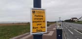Signs remind visitors that parking charges are now in place all year round