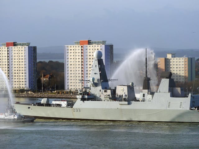 HMS Dauntless with water cannon tug escorts passing the Gosport tower blocks as she deployed to the Gulf from her home base in Portsmouth on 2 January 2015.
Picture: Courtesy of Stephen Ashton