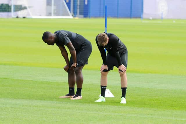 Christian Saydee and a team-mate take a breather after being put through their paces on the opening day of pre-season training. Picture: Sarah Standing (290623-8898)