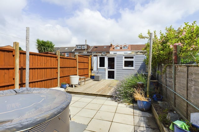 Outside is a low maintenance garden with a paving area leading up to a decking area and shed across the rear.