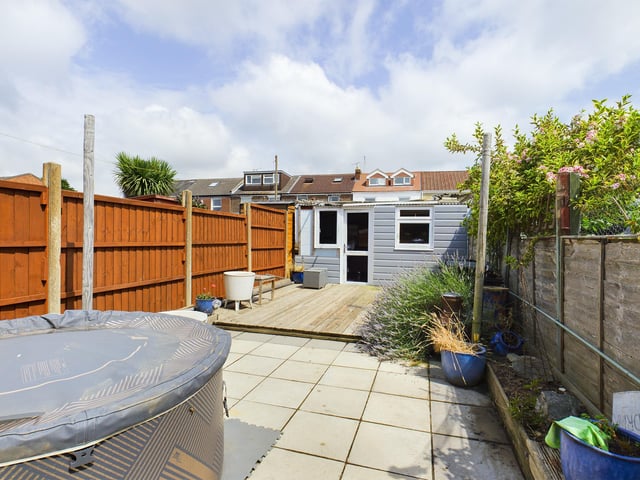 Outside is a low maintenance garden with a paving area leading up to a decking area and shed across the rear.
