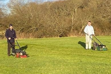 Josh Jeffery, manager of Widbrook United Girls and Colin White, a father of one of the players, cutting the grass