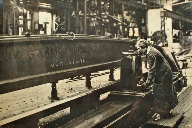 A female dockyard worker controls the cutting machinery.