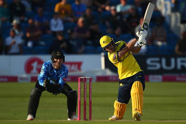 Lewis McManus  hits out while Sussex's Philip Salt watches on. Photo by Charlie Crowhurst/Getty Images.