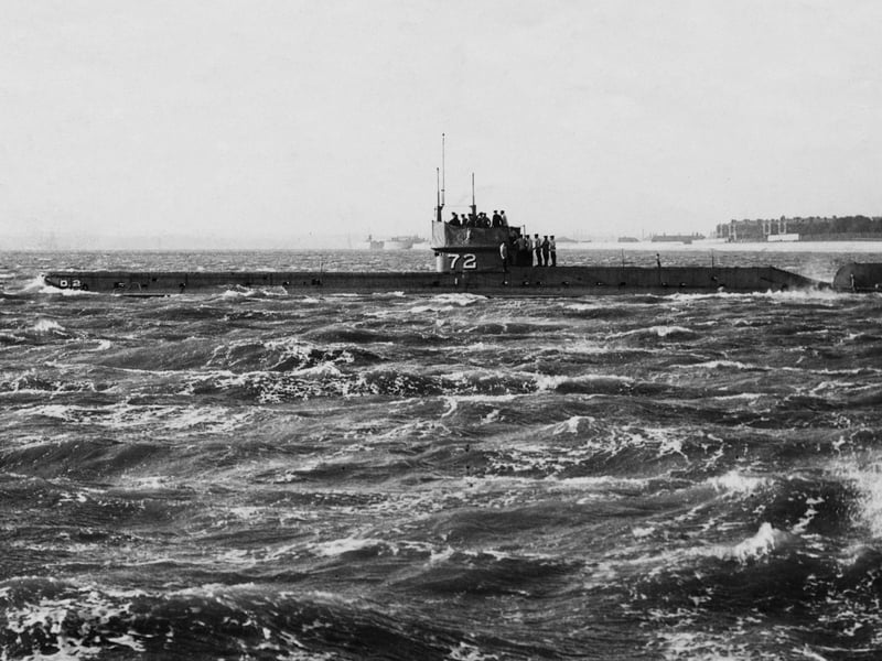 Winston Churchill, First Lord of the Admiralty stands on the conning tower with the officers and crew of the Royal Navy D-class submarine HMS D2 as it leaves Portsmouth Harbour for Spithead on 6 November 1911. D2 was later rammed and sunk by a German patrol boat off Borkum on 25 November 1914, leaving no survivors.  (Photo by Topical Press Agency/Hulton Archive/Getty Images)