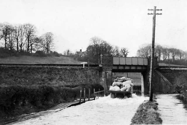 THEN: Dean Lane End, on the road from Rowlands Castle to Finchdean. The road is flooded by the Lavants that rise every seven years without fail. Picture: Barry Cox  postcard collection.