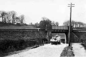 THEN: Dean Lane End, on the road from Rowlands Castle to Finchdean. The road is flooded by the Lavants that rise every seven years without fail. Picture: Barry Cox  postcard collection.