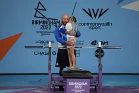Micky Yule hugs his daughter after winning the bronze medal for the men's heavyweight para powerlifting final at the Commonwealth Games at The NEC in Birmingham. Picture: AP Photo/Aijaz Rahi