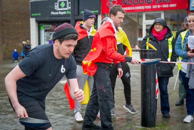 A pancake race taking place in The Precinct, Waterlooville. Pictured: Local businesses Box Chilli and Hampshire Flag going head to head. Picture: Habibur Rahman