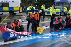 Police officers detain protesters from Insulate Britain occupying a roundabout leading from the M25 motorway to Heathrow Airport in London. Picture: Steve Parsons/PA Wire