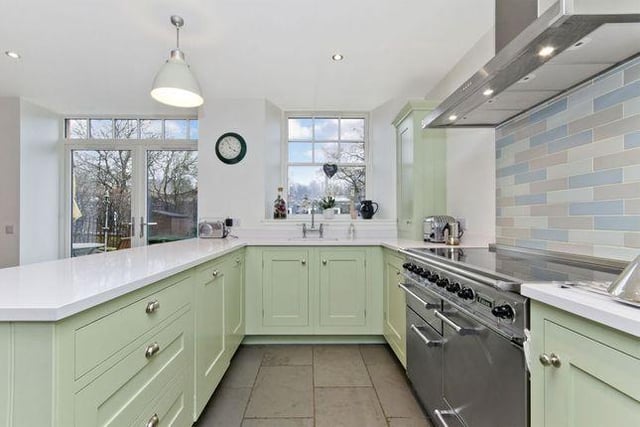 The kitchen is inspired by a classic Victorian kitchen and boasts a flagstone-style floor and Shaker-style cabinets, and is paired with mint green hues