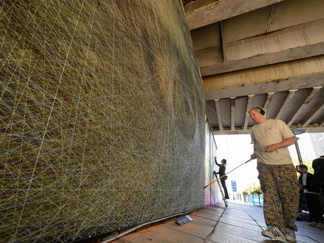 Pictured is: Perspicere adds another strand to his artwork out side Portsmouth and Southsea railway station Picture: Keith Woodland (140921-35)