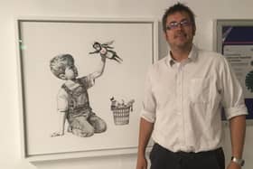 Recording radiographer Humphrey Hardless, from Southsea, next to the Banksy at Southampton General Hospital. Picture: Southampton General Hospital/PA Wire