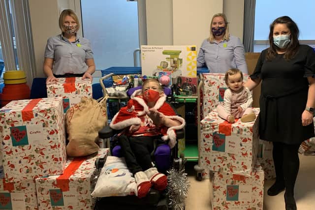 Waitrose in Gosport delivered 14 boxes of toys, games, puzzles, books and craft items to QA Hospitals paediatric department. Pictured: Hazel Neligan, Julie Sheppard and Lisa Ireland with Lisa's daughter Abigail and store regular Hope Ayres