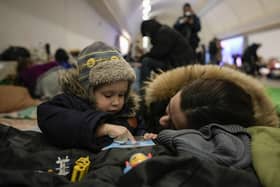 A woman and her child sit on the pavement in a subway station turned into a shelter in Kyiv, Ukraine, Tuesday, March 8, 2022. Demands for ways to safety evacuate civilians have surged along with intensifying shelling by Russian forces, who have made significant advances in southern Ukraine but stalled in some other regions. Efforts to put in place cease-fires along humanitarian corridors have repeatedly failed amid Russian shelling. (AP Photo/Vadim Ghirda)