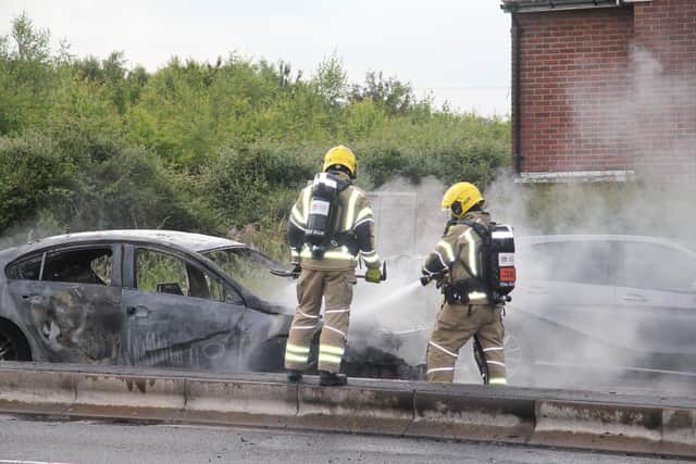 Firefighters next to the vehicle. Picture: Bob Hind