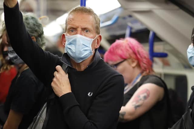 COVER-UP: A face mask wearer on the Tube. Picture: Getty